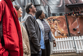 People exploring colorful murals on a street art walking tour in Belfast.