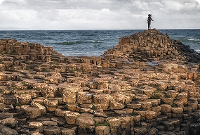 Visitors standing at the top of the Giant’s Causeway, overlooking Ireland’s iconic basalt columns.