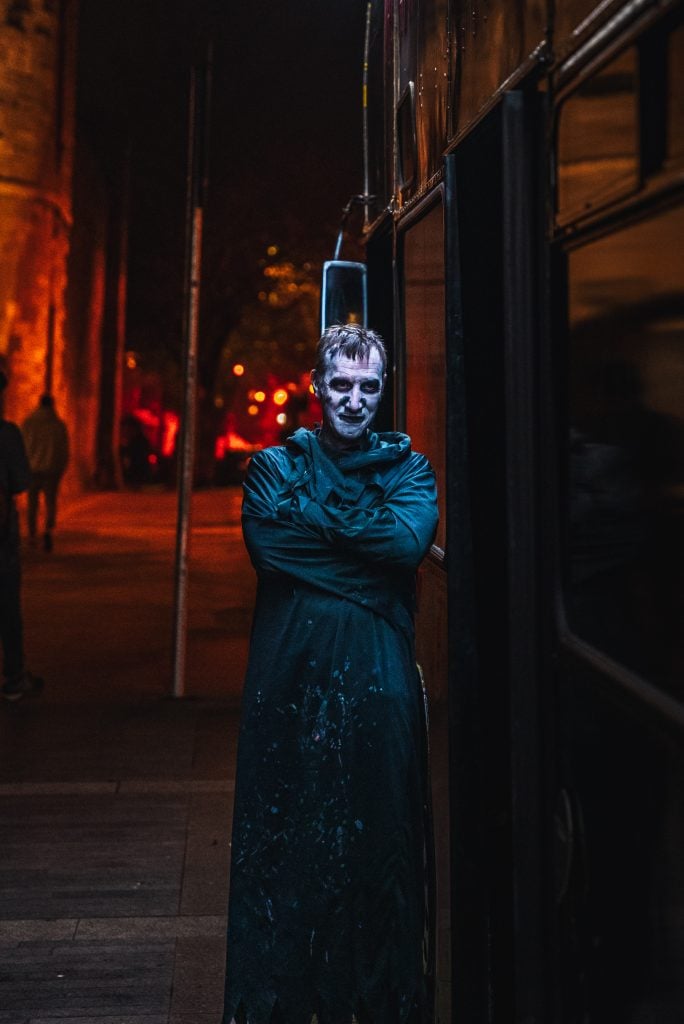 Actor in a spooky costume performing on the Gravedigger Ghost Bus Tour in Dublin.