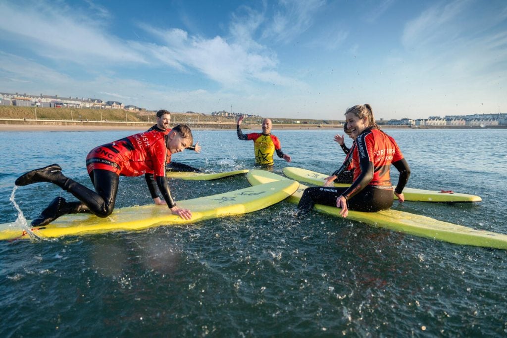 Young people taking surfing lessons at Portrush Surf School, Ireland.