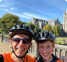 A man and child taking a selfie on a Dublin bike tour with St. Patrick’s Cathedral in the background.